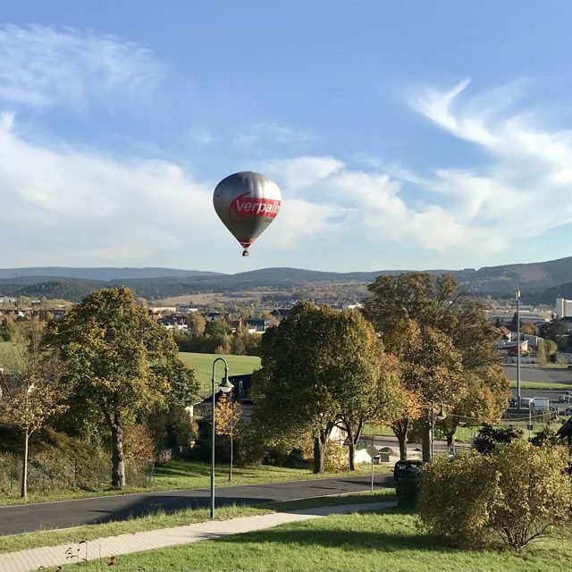 Heißluftballon über einer Hügellandschaft