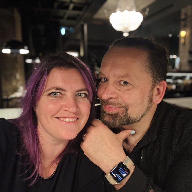 Sören und eine Frau mit lila gefärbten Haaren, Wange an Wange