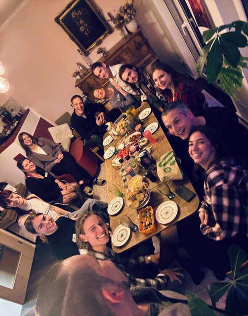 Gemeinsames Essen an einem langen Tisch mit vielen Menschen